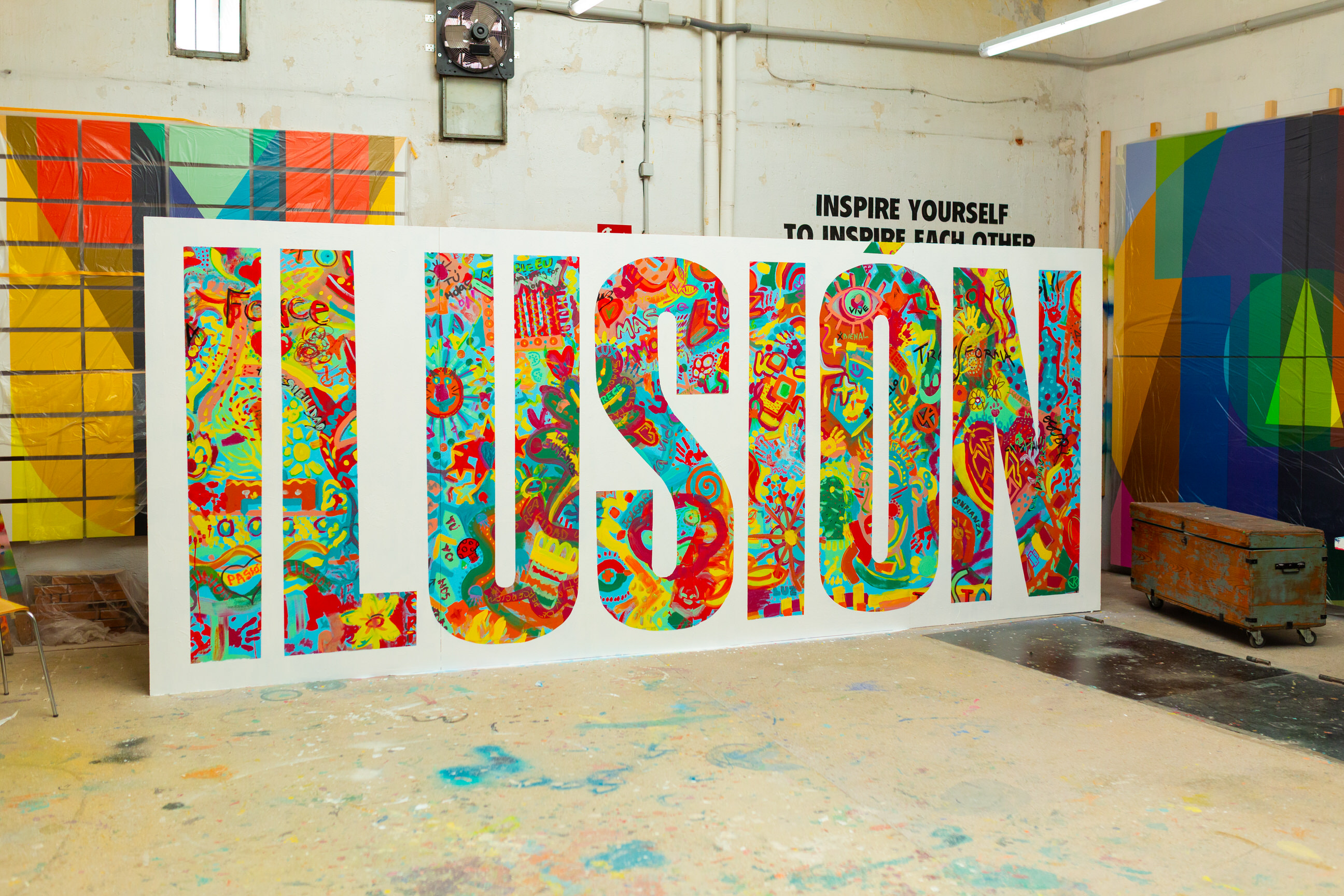 Imagen de un mural donde sen el taller de Boa Mistura, donde se ve la palabra Ilusión. 