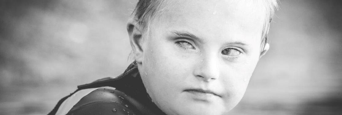Fotografía de un niño con el pelo y la cara mojados por haber estado nadando