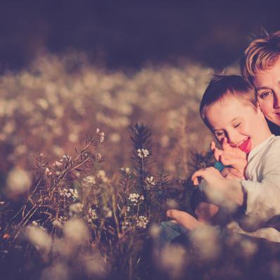 Imagen del niño Ioan Inchusta sonriente, en el campo, abrazado por su madre