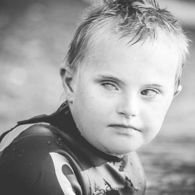 Fotografía de un niño con el pelo y la cara mojados por haber estado nadando